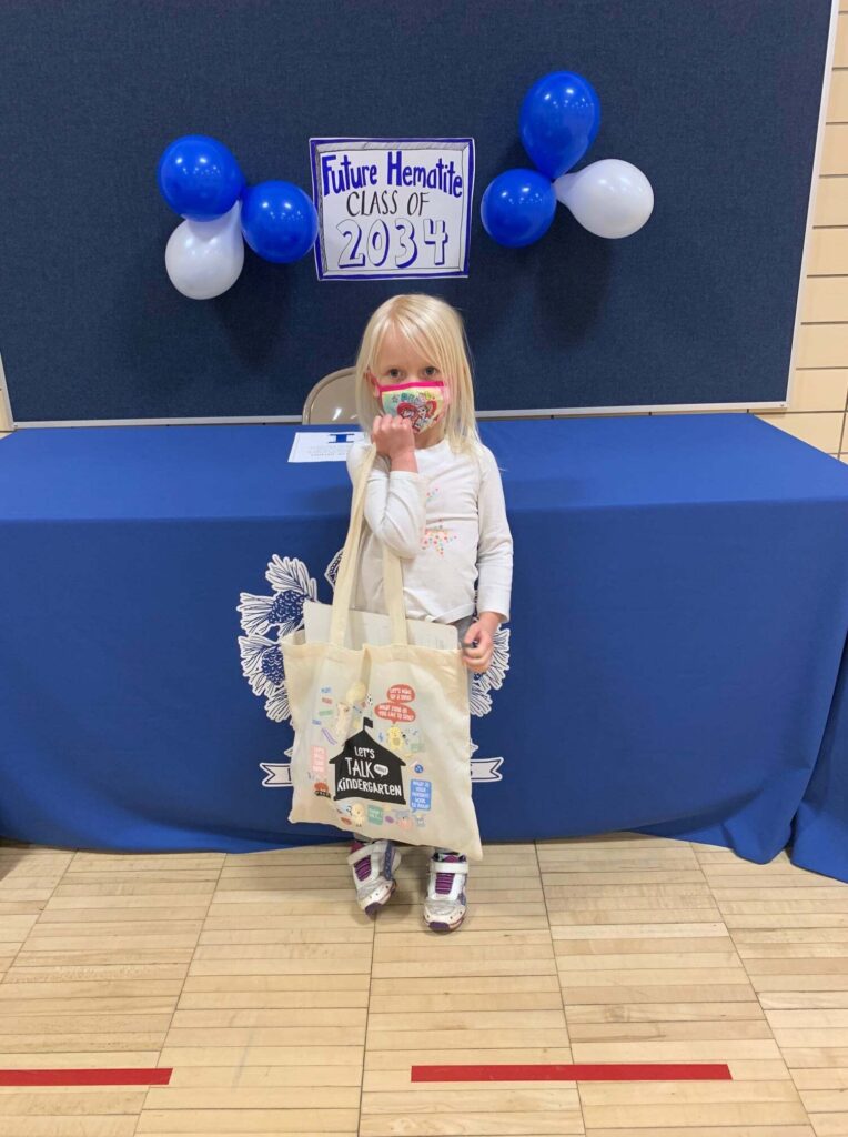 Child holding Kindergarten Readiness bag.