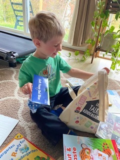 Child opening a Kindergarten readiness bag.